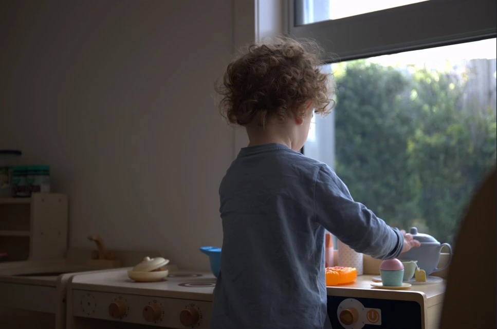 Toddler playing in the home corner kitchen at Little Wonders childcare Ballarat
